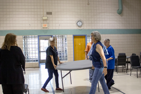 ESA women carry a table in the Heartspring School gymnasium as they set up for the Family Weekend dance.